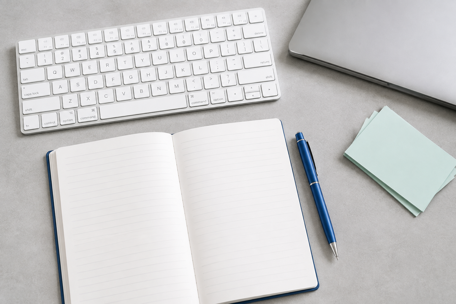 Keyboard and open notebook in a writing workspace